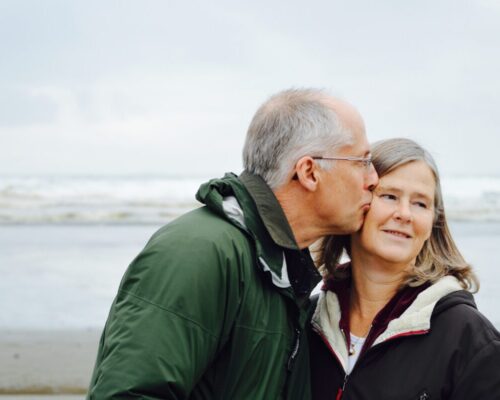 Older couple kissing on a beach